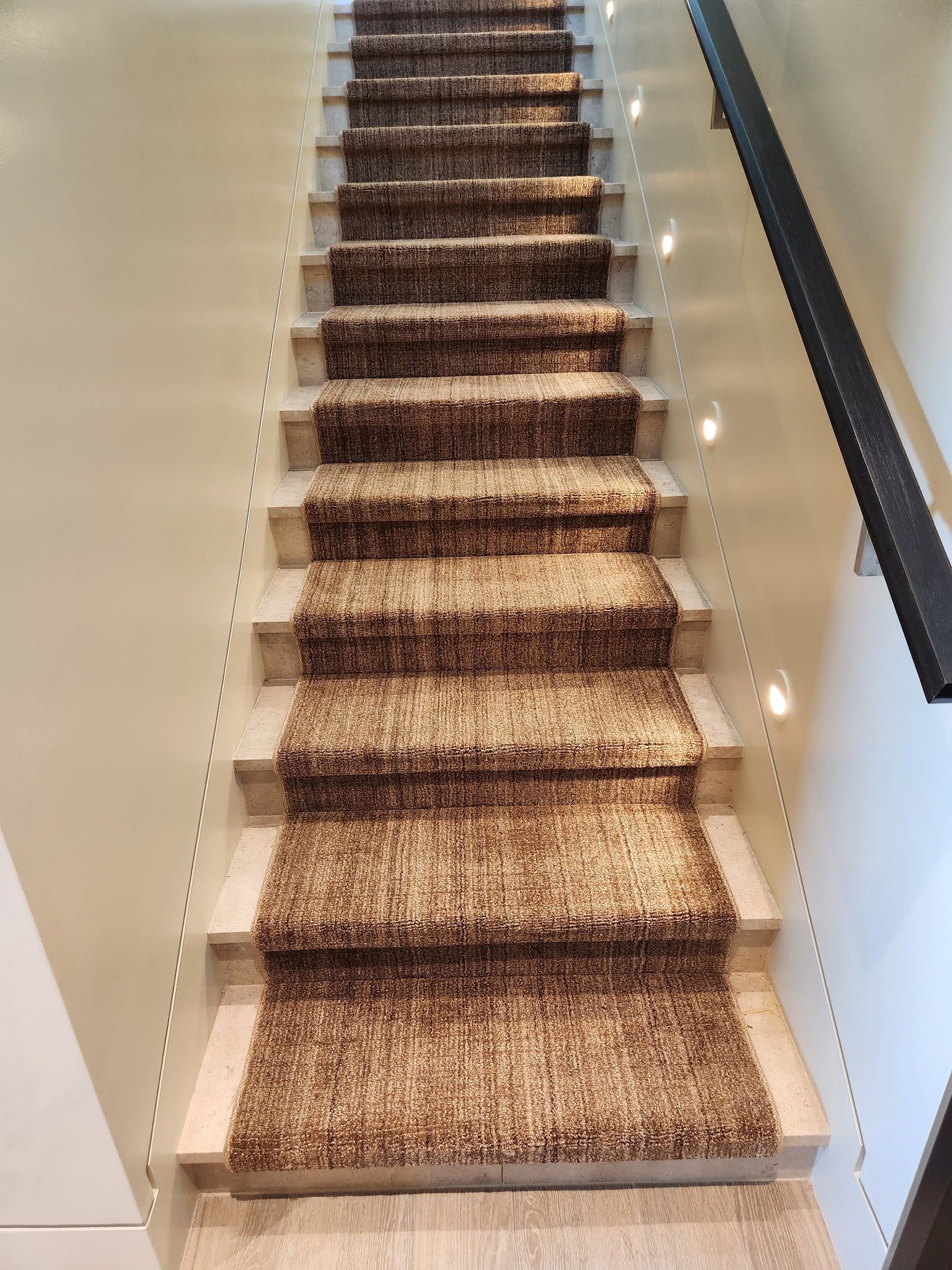 Staircase with a textured carpet runner by Jim Lusk, carpet from Benson Carpet and Floors